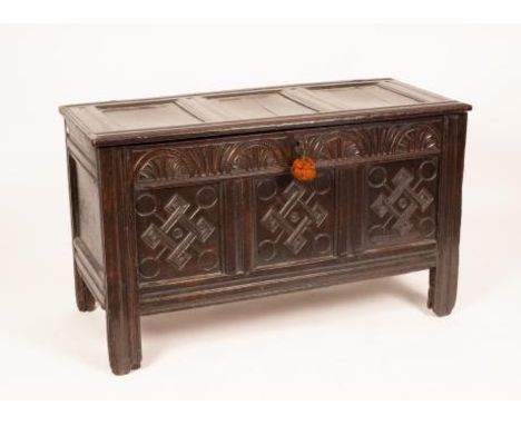 A 17th Century oak coffer, the triple panel cover above lunette carved frieze and carved triple panel front, 120cm wide, 54cm