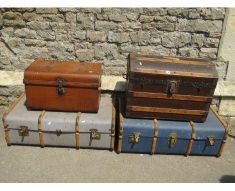 A vintage wooden lathe bound domed top travelling trunk together with a tin trunk and two wooden and fibre cabin trunks, one 