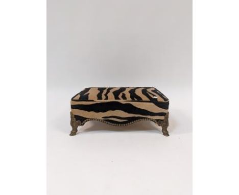 A rectangular footstool with Zebra print upholstery, on gilt hoof feet, 43cm wide 