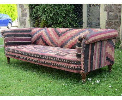 19th century Chesterfield style sofa with scrolled arms, raised on turned and fluted supports with later Kelim carpet finish,