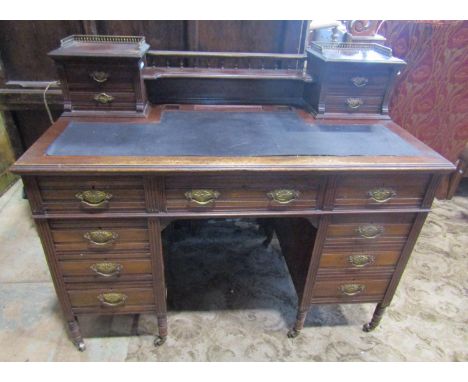 A late 19th century kneehole writing desk by Maple &amp; Co, the nine drawers set beneath an inset leather top with raised ba