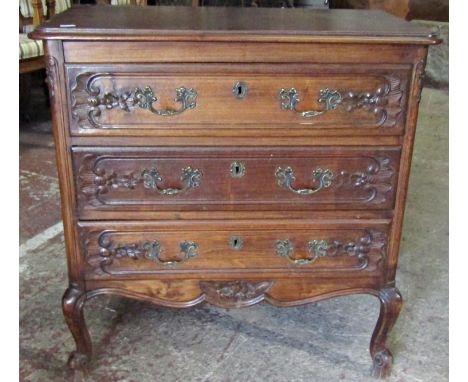 A small stained oak and beechwood three drawer commode with carved detail, shaped apron and scroll cabriole supports, 70 cm w