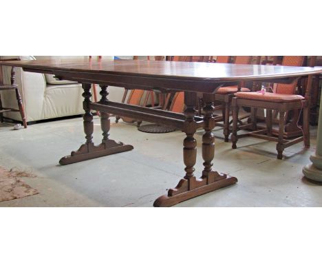 An Ercol elm extending refectory table with two additional leaves raised on four turned supports together with eight Ercol di