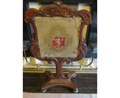 A mid Victorian period oak firescreen, the carved outline with acanthus and other detail on a platform base with petite point