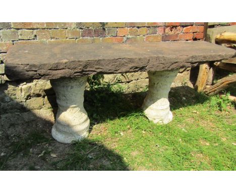 A three sectional garden bench with rectangular thick natural stone top raised on a pair of cast composition stone pedestals 