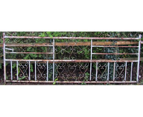 A large weathered tubular steel framed driveway/field gate with open scrollwork panels and simple latch, 353 cm wide x 125 cm