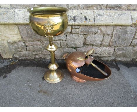 A brass jardiniere and stand with lions mask and ring handles, 67 cm high x 30 cm diameter together with a copper helmet shap