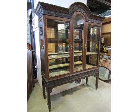 A good quality light Victorian period mahogany display cabinet with glazed panelled front and sides set beneath a carved frie