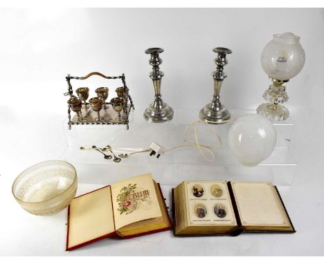 A small quantity of plated ware to include candlesticks, egg cups, egg cup holder and small spoons, a vintage glass oil lamp 