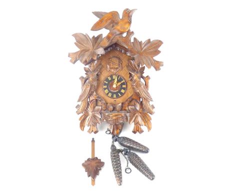 A German 20th century cuckoo clock with oak leaf, bird and chick carving.Please note that this lot is not suitable for our in