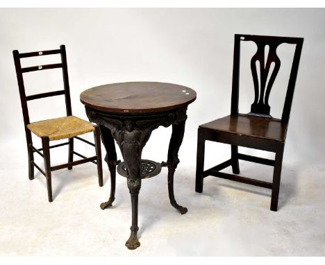 An early 20th century cast iron garden table with caryatid supports to outswept paw feet, interspersed with shields inscribed