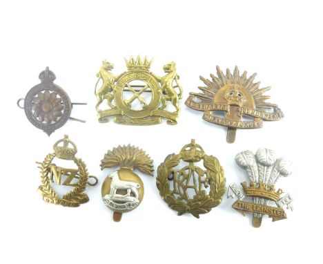Seven military cap badges comprising the Royal Canadian Air Force, New Zealand Forces, Australian Commonwealth Military Force