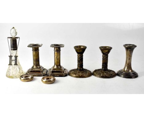 A pair of silver column-form squat candlesticks on stepped square bases, a pair of repoussé decorated candlestick, a single c