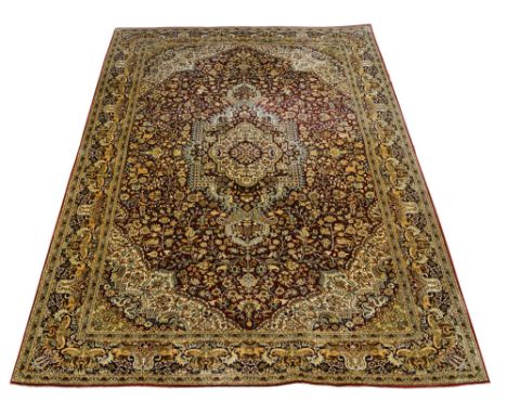 A modern silk Tabriz carpet, with geometric central medallion, woven with foliate designs on red ground with cream ground spa