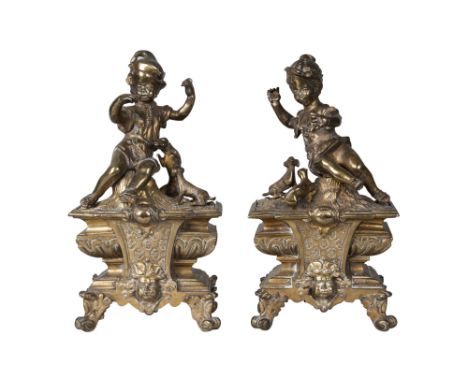 A pair of French brass chenet, late 19th century, each modelled with a boy and girl playing with puppies, on naturally modell