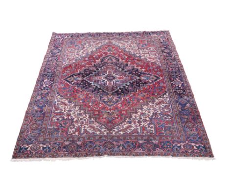 A Heriz carpet, with medallion in red field and ivory spandrels, with charcoal main border, (reduced in size) 300cm x 253cm  