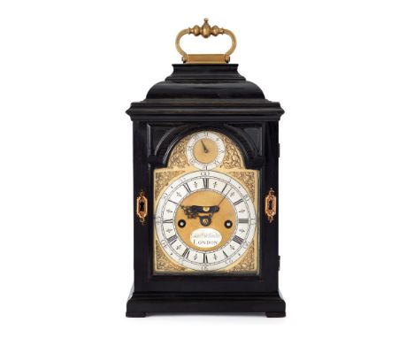 An 18th century ebony table clock by Daniel Delander, the inverted bell top with knopped brass carrying handle, the case with