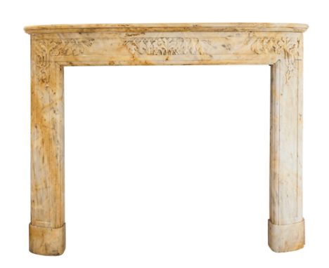 An Art Deco fireplace surround, circa 1925, in pale veined Giallo di Siena marble with finely carved floral and foliate detai