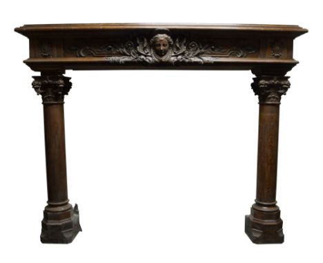 A tall French Renaissance style carved oak chimneypiece, 19th century, with a stepped shelf above a boldly carved frieze cent