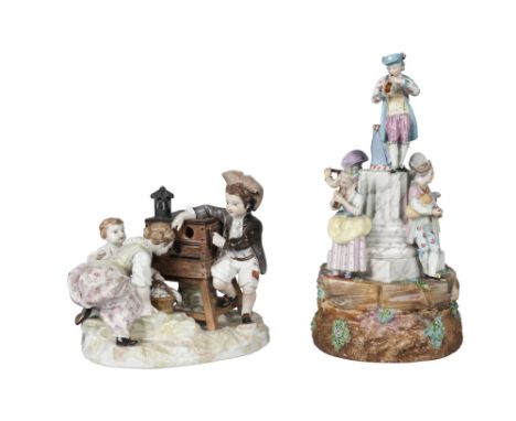 A Berlin KPM porcelain figure group of a boy helping two girls in front of a magic lantern show, 19th century, printed and bl