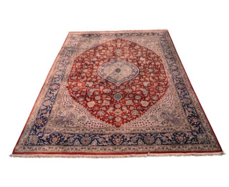 A Tabriz part silk carpet, the oval ivory centred pole medallion in a deep red field with scrolling flowering stems, with ivo