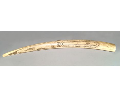 An Inuit walrus tusk cribbage board, late 19th/early 20th century, incised and filled with line decoration of a panel of a se