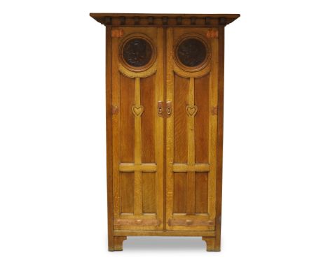 An Arts and Crafts oak wardrobe retailed by Morgan & Co, Cardiff, early 20th Century, the moulded cornice above two panelled 