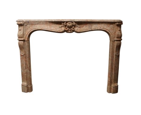 A Louis XV style chimneypiece, in red and grey veined marble with a well carved central floral cartouche on serpentine shaped