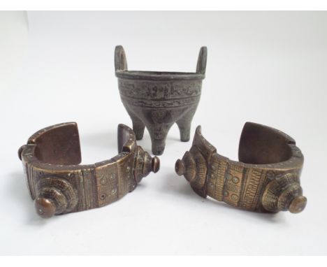 Bronze miniature cauldron standing on tripod feet together with a pair of bronze and a pair of African bronze Manila/slave ba