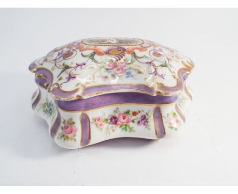 French porcelain trinket box, the lid decorated with a cherub within floral borders, signed Remi Douard.  Approx 20cm wide 
