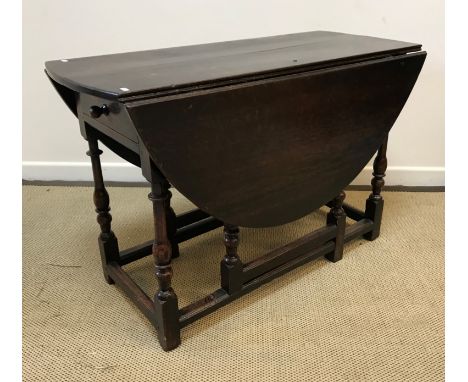 An 18th Century oak oval gate-leg drop-leaf dining table on turned and ringed supports to block feet united by stretchers, 11