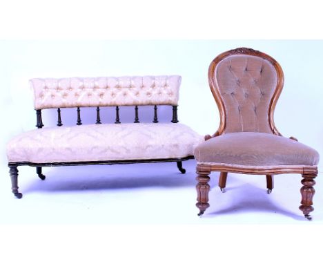 A VICTORIAN EBONISED AND PARCEL GILT SMALL SOFA with turned supports to the upholstered back and overstuffed upholstered seat