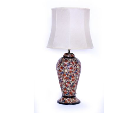 A 20TH CENTURY PAPIER MACHE BALUSTER TABLE LAMP decorated with blue, pink and red flowers and cream shade 80cm including the 