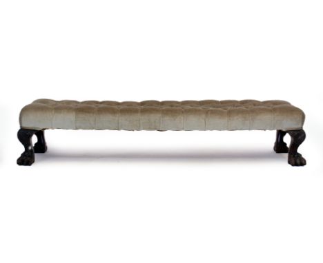 A LATE 19TH CENTURY LONG LOW BUTTON UPHOLSTERED FOOTSTOOL with cabriole legs and hairy paw feet 130cm wide x 33cm deep x 26cm
