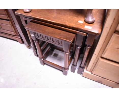 A dark oak nest of three Ercol or Priory style occasional tables