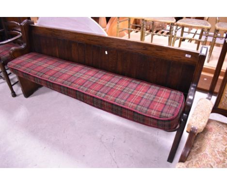 A traditional oak pew, with bespoke cushion in red tweed , width 190cm