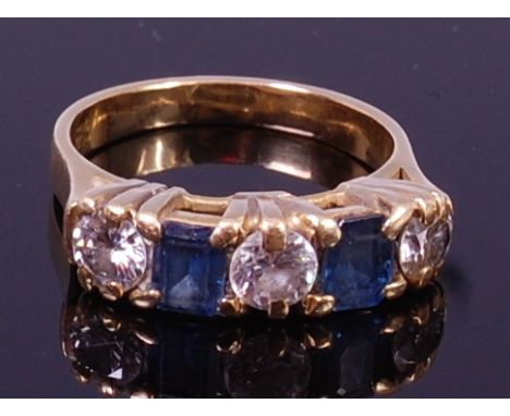 An 18ct gold, sapphire and diamond ring, arranged as twin baguette cut sapphires dispersed by three diamonds, total diamond w