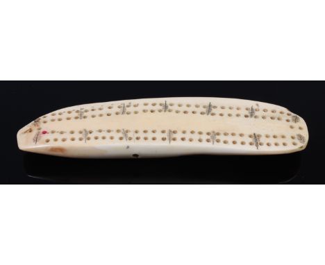 A 19th century whale-tooth cribbage scorer, with scrimshaw leaf decoration, length 17cm 