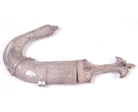 A Yemeni jambiya knife and scabbard, having intricately decorated white metal handle and scabbard, 38cm