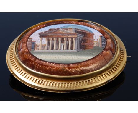 A 19th century micro-mosaic brooch, the oval plaque depicting Roman architecture within a hardstone set surround and yellow m