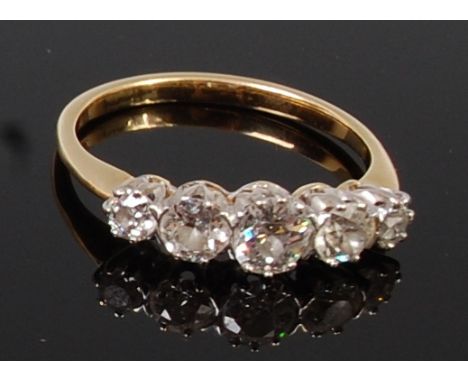 An 18ct gold and diamond five stone ring, the centre old brilliant weighing approx 0.5ct, flanked to either side by two small