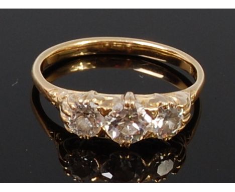 An 18ct gold and diamond three stone ring, the centre claw set old brilliant weighing approx 0.5ct, flanked to either side wi