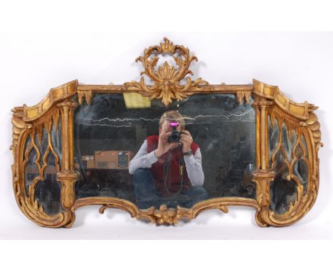 An 18th century continental giltwood and gesso wall mirror, the mirrorplate surmounted with central acanthus leaves flanked b