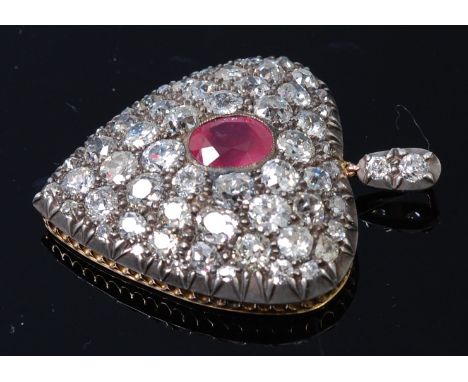 An early 20th century yellow and white metal, ruby and diamond set heart shaped pendant, the whole pavé set with a central ov
