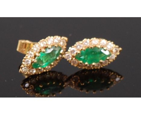 A pair of 18ct gold, emerald and diamond set ear studs, each of elliptical form, the claw set marquise cut emeralds in a surr