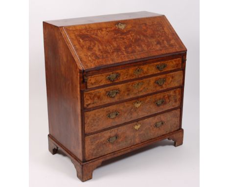 A George II figured walnut and walnut writing bureau, with all-over feather-banding, the hinged fall opening to reveal fitted