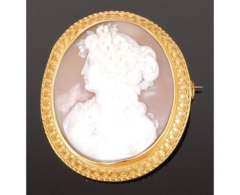 A late 19th century carved shell cameo brooch, depicting profile portrait of a maiden with flowers in her hair, the whole hou