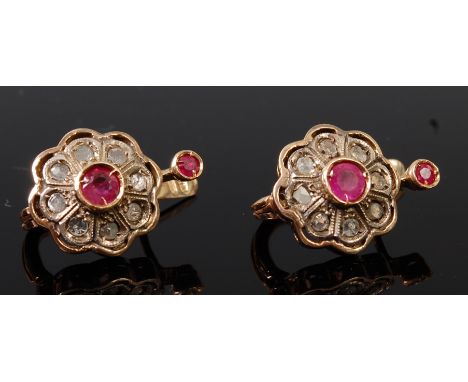 A pair of antique yellow metal, ruby and diamond set ear clips, each having centre illusion set round cut ruby in a surround 