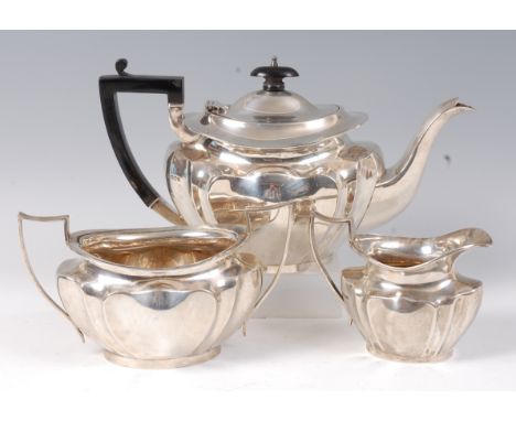An Edwardian silver three piece teaset, comprising; teapot, twin handled sugar and cream, each of lobed oval form and having 