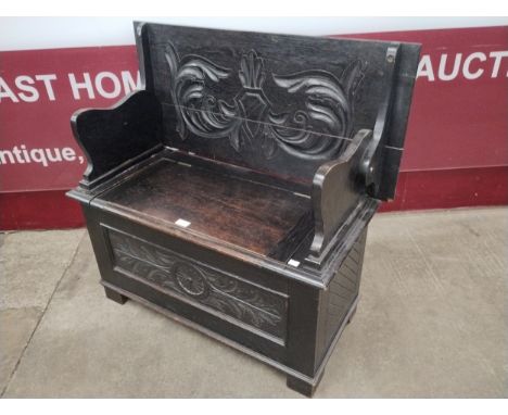 A Victorian Jacobean Revival carved oak monk's bench 